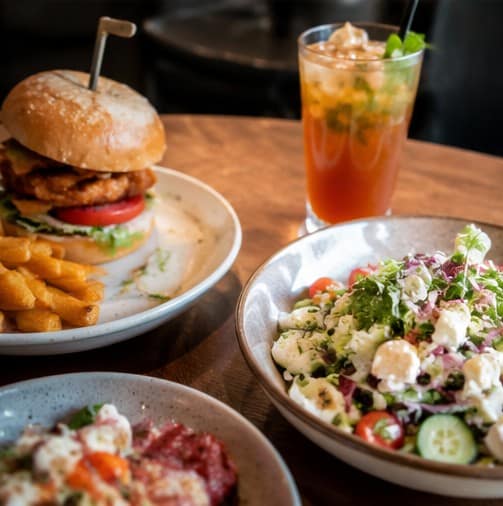 Gourmet burger with chips and refreshing drink at Spargo’s Café + Bar